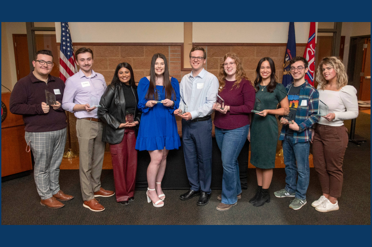college students standing holding crystal awards